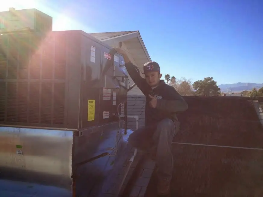 HVAC technician performing Boiler Repair on a rooftop unit in Aptos